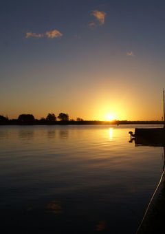 Untergehende Sonne: das Wasser und die Menschen an Bord kommen am Abend zur Ruhe