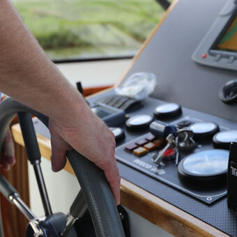 Ein Mann am Steuer eines Motorboots.